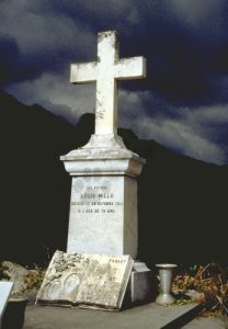 Le soleil éclaire encore la croix d'une tombe dans cimetière dans un village de l'arrière-pays niçois, quelques minutes avant un fort orage. Inscription de la pierre tombale: "Ici repose Louis Millo, décédé le 29 octobre 1914 à l'âge de 79 ans".